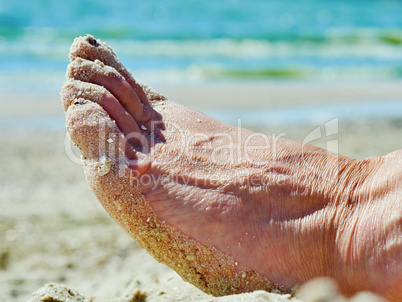 Foot in the sand on the beach