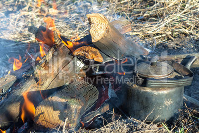 Burning fire and a kettle near the fire.