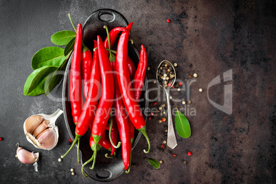 red hot chili pepper corns and pods on dark old metal culinary background