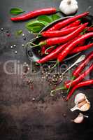 red hot chili pepper corns and pods on dark old metal culinary background