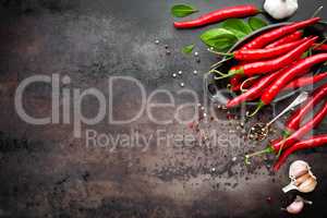 red hot chili pepper corns and pods on dark old metal culinary background