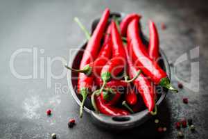 red hot chili pepper corns and pods on dark old metal culinary background