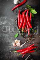 red hot chili pepper corns and pods on dark old metal culinary background