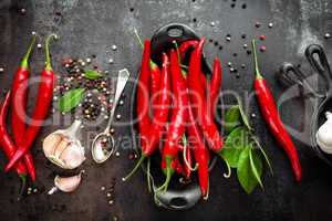 red hot chili pepper corns and pods on dark old metal culinary background