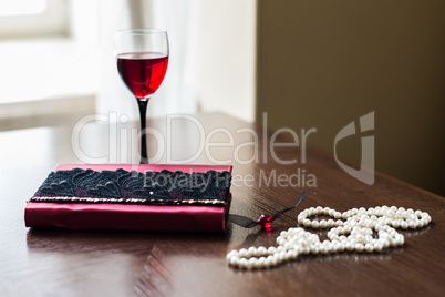 Book, glass of wine, beads