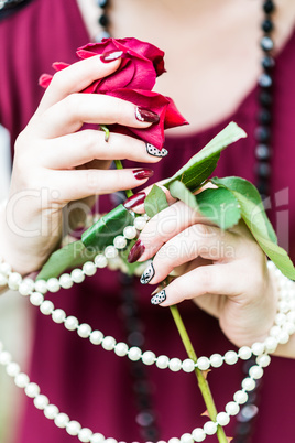 women's hands holding rose, pearl