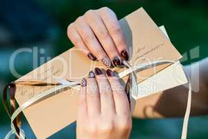 Women's hands holding mail envelope