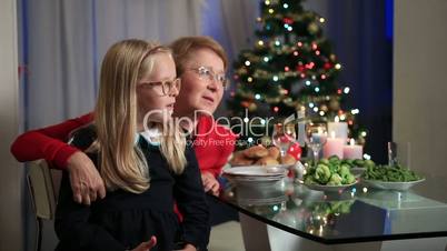 Little girl sitting on granny's lap on Christmas