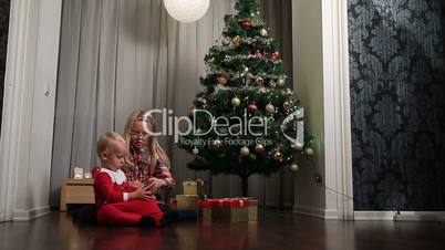 Little boy and girl opening presents on Christmas