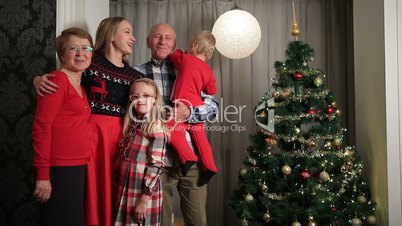 Happy family on Christmas Eve by Xmas tree