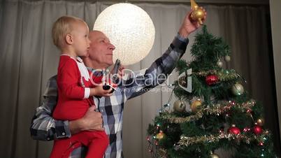 Grandfather with boy decorating christmas tree