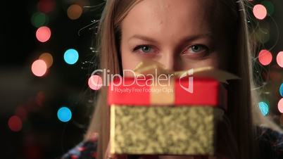 Happy young woman holding christmas present box