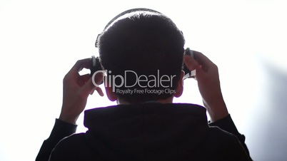 Back view of a man listening music with headphones