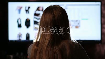 Back view of woman shopping online with computer
