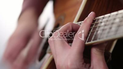 Man's hand playing guitar
