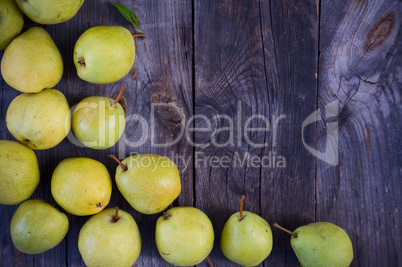Small yellow ripe pears on a wooden gray surface