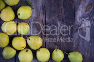 Small yellow ripe pears on a wooden gray surface