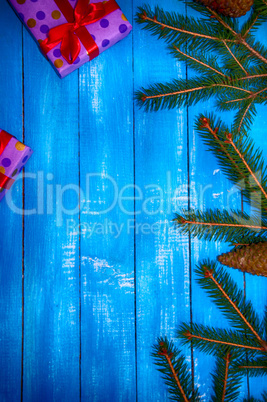 Christmas blue wooden background with branches of spruce