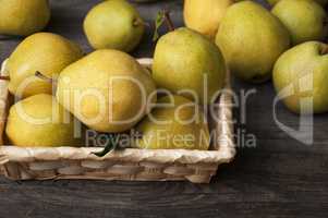 Fresh ripe yellow pears in a wicker basket