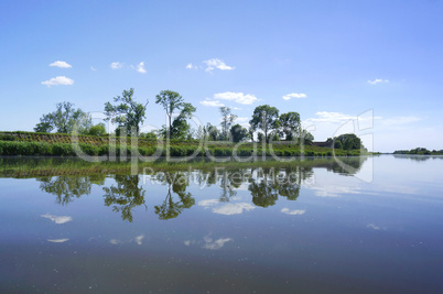 the reflection of the shoreline in the lake, the surface of the lake, calm