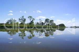 the reflection of the shoreline in the lake, the surface of the lake, calm