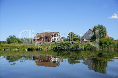 a lonely old house on the lake, the houses reflected in the lake surface of the lake, calm