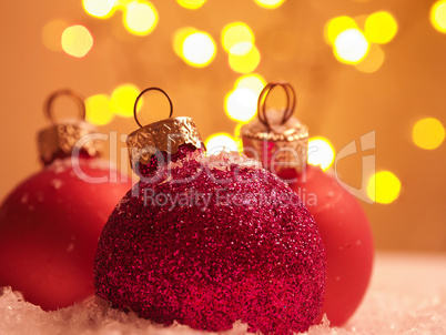 Three Christmas baubles in snow