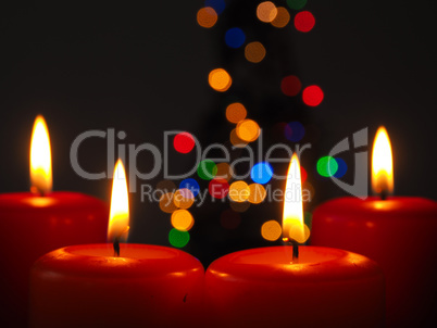 Burning Advent candles with Christmas tree lights