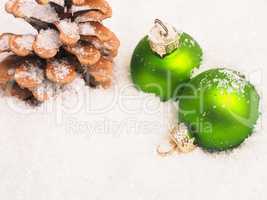 Green vintage Christmas baubles in snow