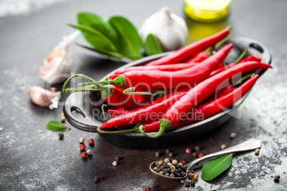 red hot chili pepper corns and pods on dark old metal culinary background