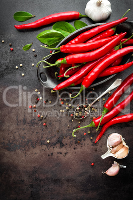 red hot chili pepper corns and pods on dark old metal culinary background