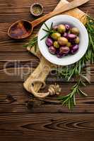 italian food ingredients, rosemary, olives, olive oil on wooden background