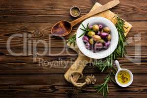 italian food ingredients, rosemary, olives, olive oil on wooden background