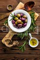 italian food ingredients, rosemary, olives, olive oil on wooden background