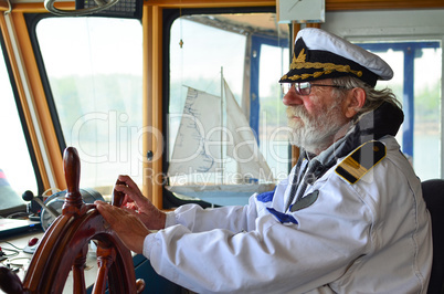 Old experienced captain in navigation cabine