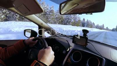 Driver Rides on an Empty Winter Road Through the Forest