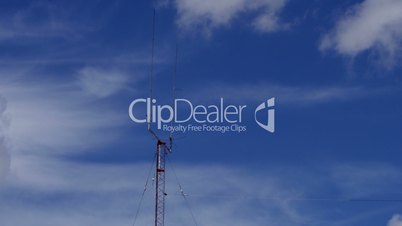 Home based dual spike Telecommunications antenna tower with clouds clearing the sky time lapse