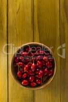Ripe rosehips in wooden plate