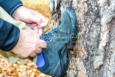 Man binds travelling shoe in the tree