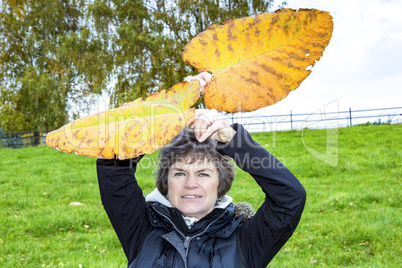 Woman holds up oversized autumn sheets