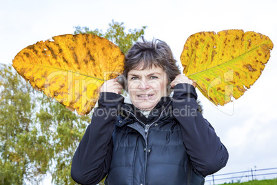 Woman holds up oversized autumn sheets