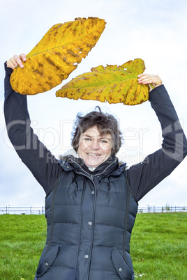 Woman holds up oversized autumn sheets
