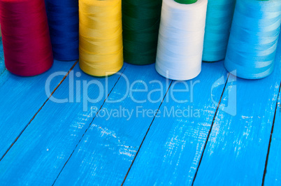 several of colored spools of thread for sewing and embroidery