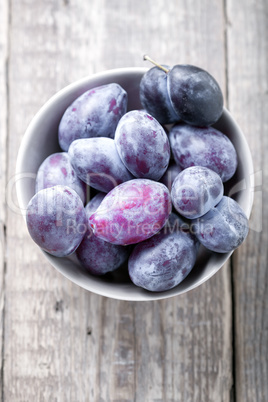 Fresh plums on a wooden table