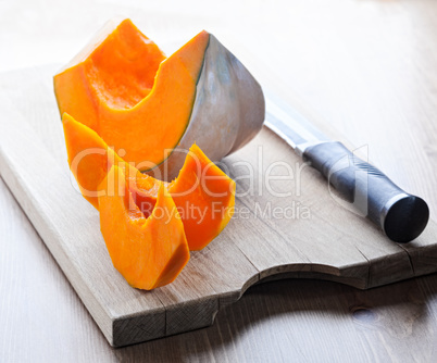 Sliced Pumpkin and knife on a wooden board