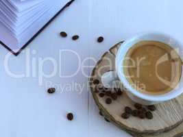 cup of coffee and open book on a white wooden background