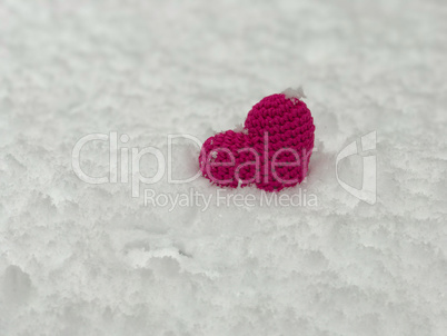 knitted red threads red heart lies on the snow