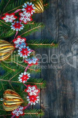 New Year and Christmas background with toys and spruce branches on a gray wooden background, top view