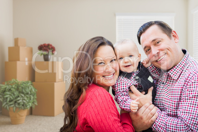 Caucasian Family with Baby In Room with Moving Boxes