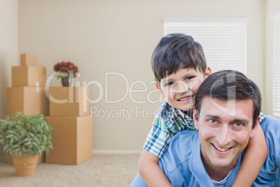 Father and Son in Room with Packed Moving Boxes and Potted Plant